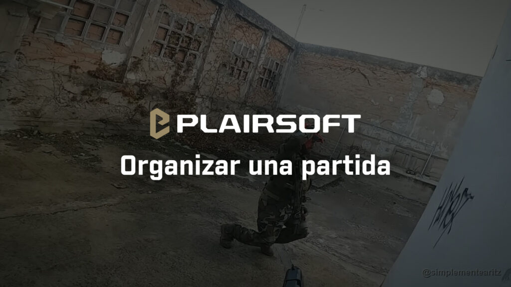 Jugador de airsoft con rodilla en tierra cubriendo una esquina en una nave industrial abandonada durante una partida táctica
