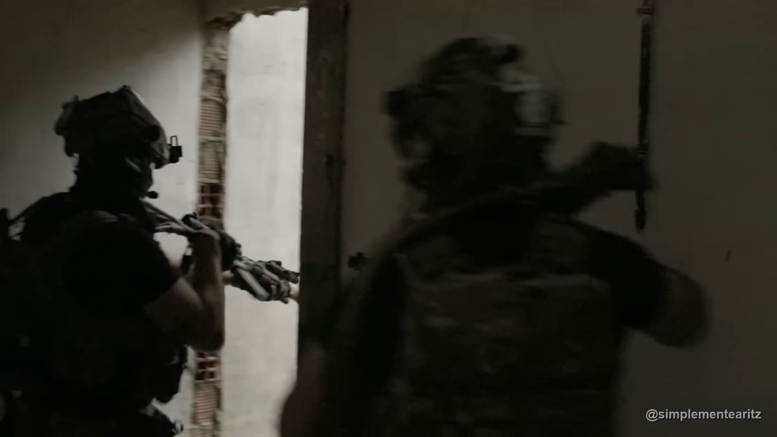 Dois jogadores de airsoft a entrar numa sala em contraluz, em silhueta