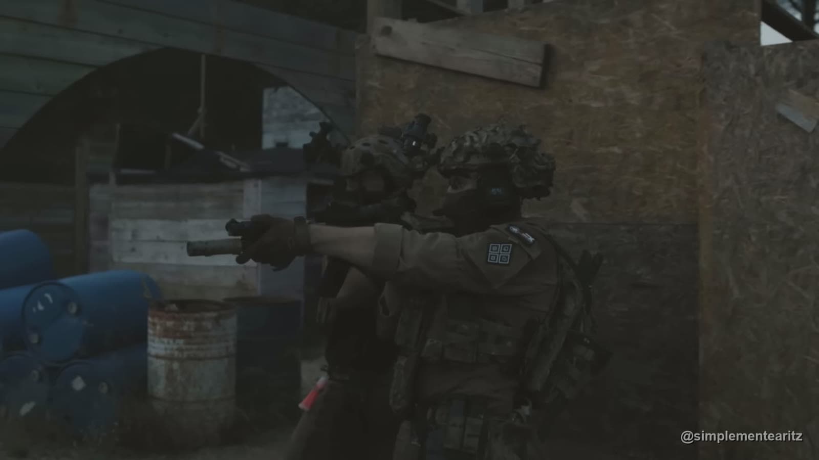 Jugador de airsoft con la pistola desenfundada en un campo de CQB con bidones y palés