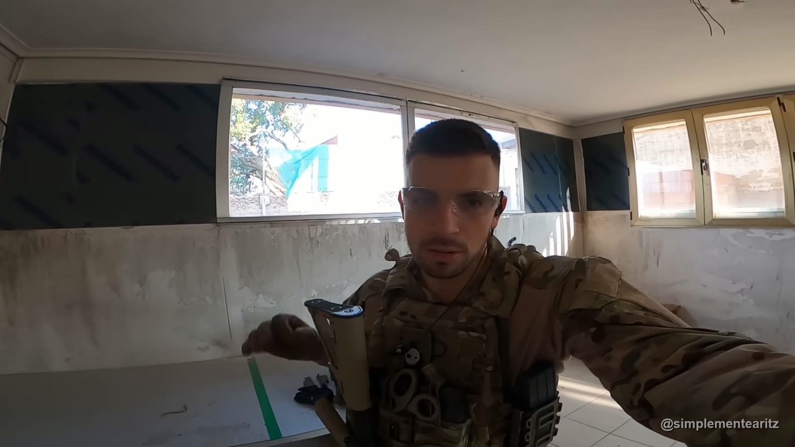 O Aritz com óculos de proteção e colete tático a falar para a câmara dentro de uma divisão de um edifício abandonado durante um jogo de airsoft