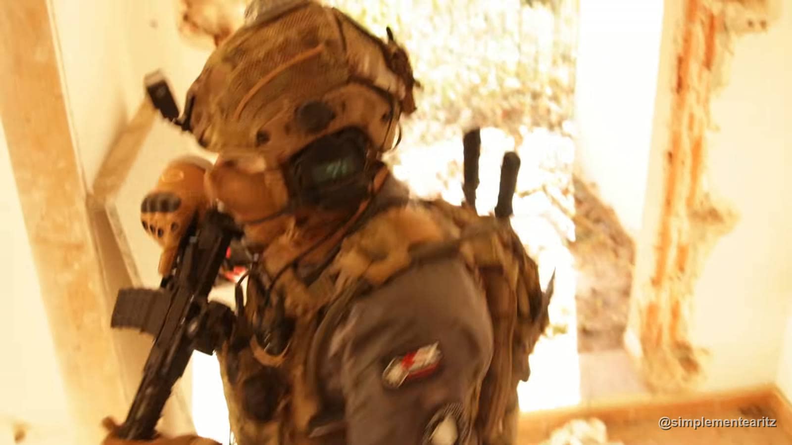 Jogador de airsoft com máscara e capacete à entrada de uma porta, à luz do fim de tarde