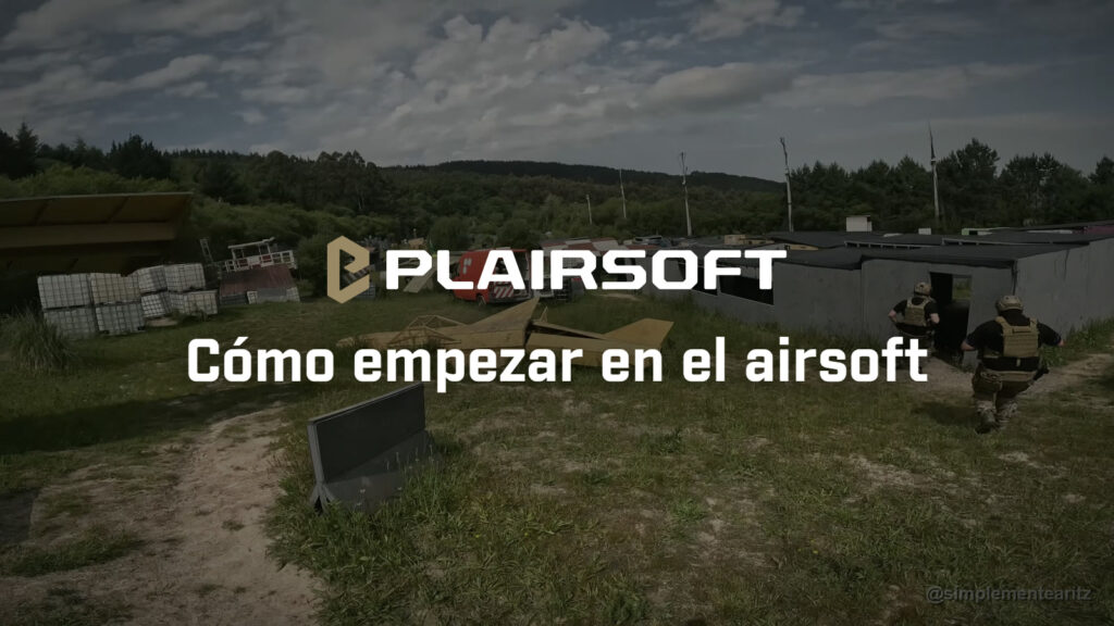 Dominguera en Soldados de Juguete (SDJ), en Larrabetzu (Bizkaia), un día de sol: dos jugadores con casco y portaplacas entran en una caseta gris, con depósitos de plástico apilados, un avión de madera amarillo y una furgoneta roja por el campo y el monte al fondo