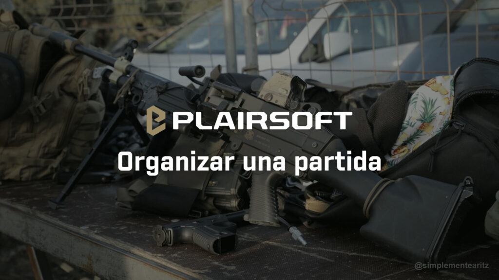 Réplica de apoyo M249 con visor holográfico, una pistola y varias mochilas sobre una mesa en un campo de airsoft, con coches aparcados detrás de la valla