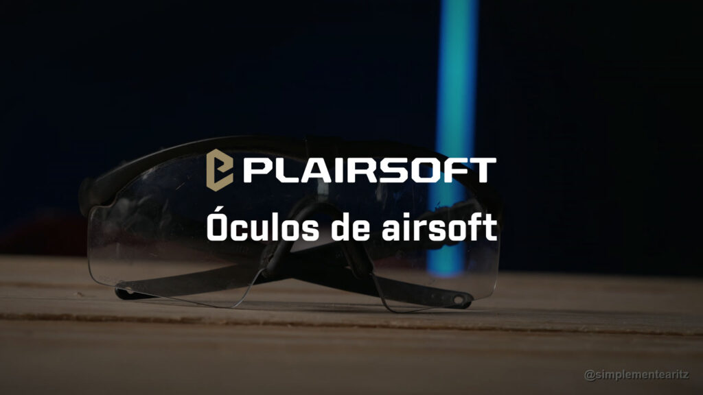 Óculos balísticos de hastes Oakley SI de lente transparente em cima de uma mesa de madeira, com a marcação da lente gravada no canto inferior