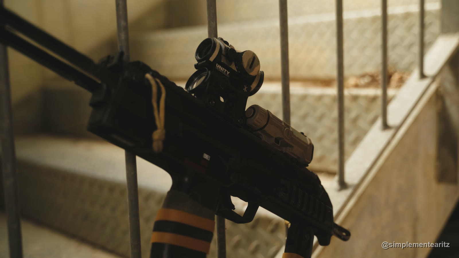 La MP7 de gas de Tokyo Marui, negra, con la culata extendida, un punto rojo y una linterna color arena, apoyada en la barandilla de una escalera
