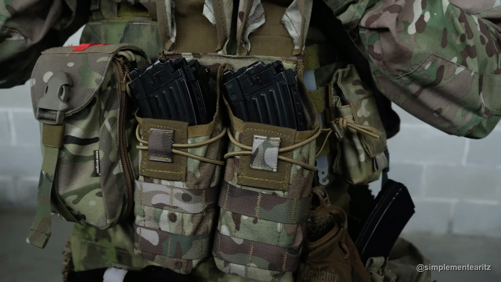 Cargadores de gas de la AKM de Tokyo Marui en dos portacargadores dobles del frontal de un chaleco de camuflaje, junto a un bolsillo de utilidades