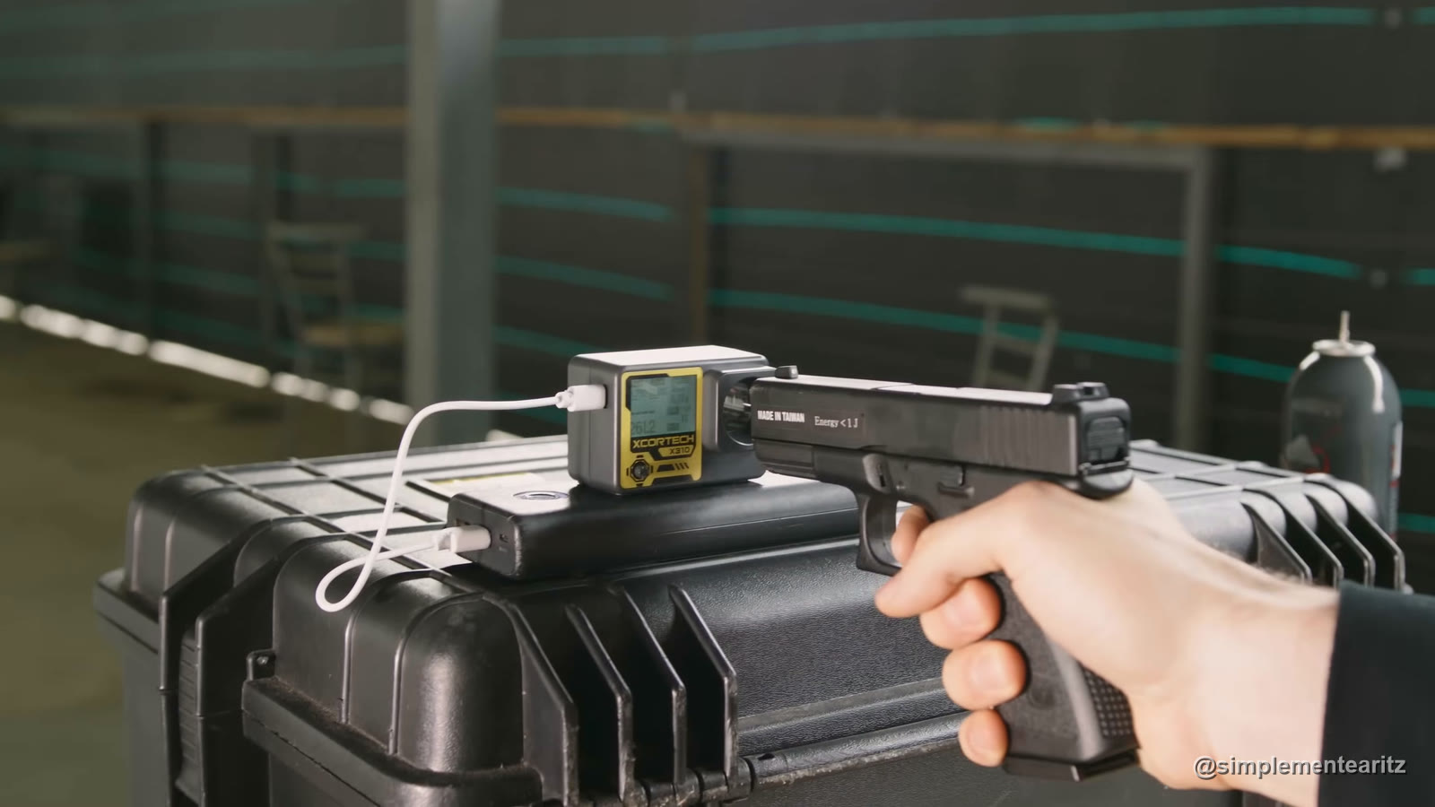 Glock 23 de Saigo, de gas, disparando a través de un cronógrafo Xcortech X310 colocado sobre un maletín, con un bote de gas al fondo