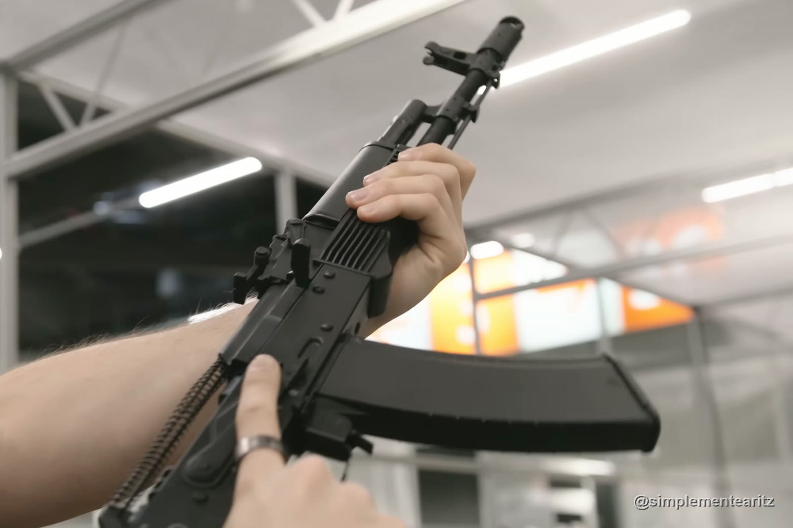 AK74M de gas de VFC con el cargador puesto, sujeta con las dos manos en un estand de la feria IWA de 2025, en Núremberg