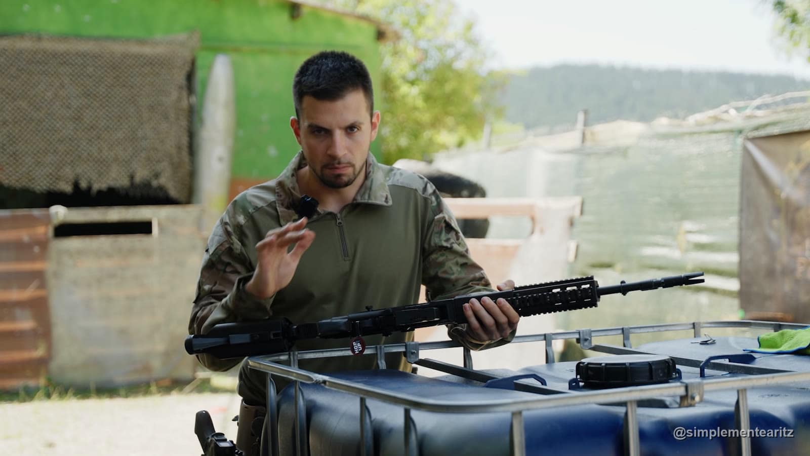 Aritz explicando una réplica M14 de CYMA con guardamanos de raíles, con la rueda del hop-up marcada junto al hueco del cargador