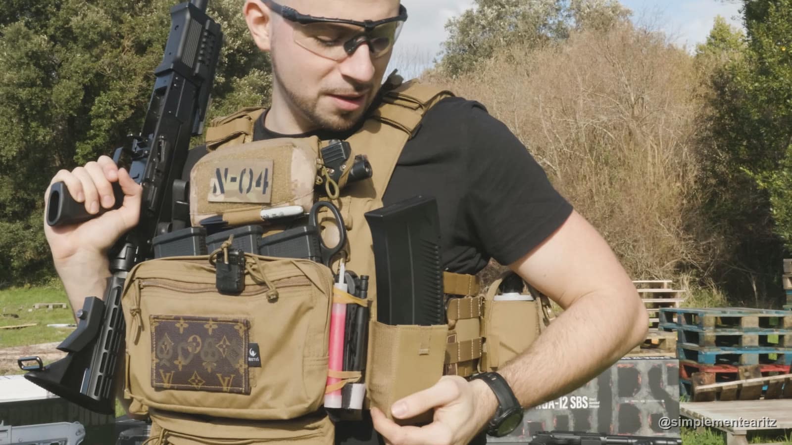 Aritz con la escopeta de airsoft Tokyo Marui Saiga 12 en la mano, metiendo uno de sus cargadores en un portacargadores de la placa portadora